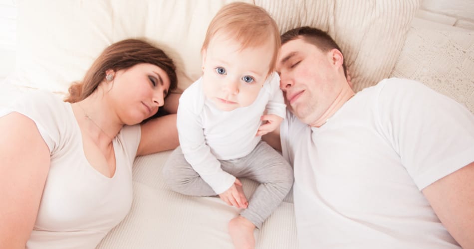 Müde Eltern mit Baby leiden unter Schlafmangel.