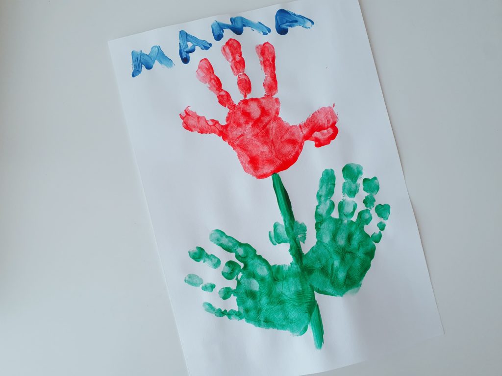 Eine Blume aus Handabdrücken von Kindern als Muttertagsgeschenk gebastelt.