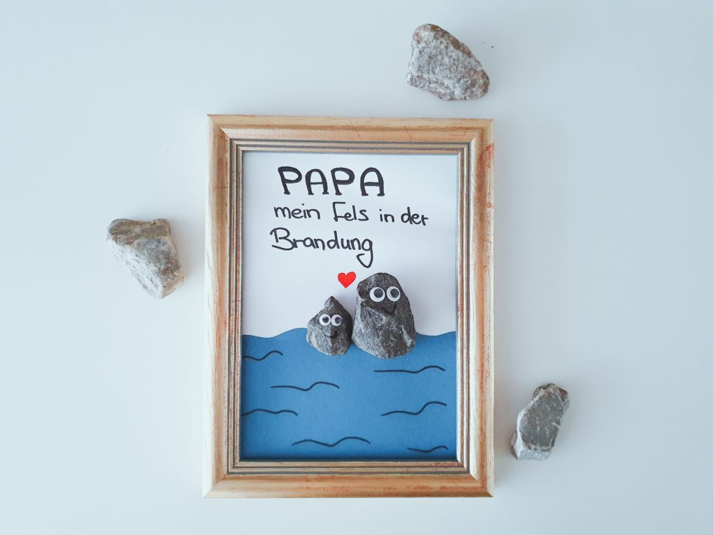 Ein Bild mit Steinen und Tonpapier als Vatertagsgeschenk mit Kindern für Papa gebastelt.