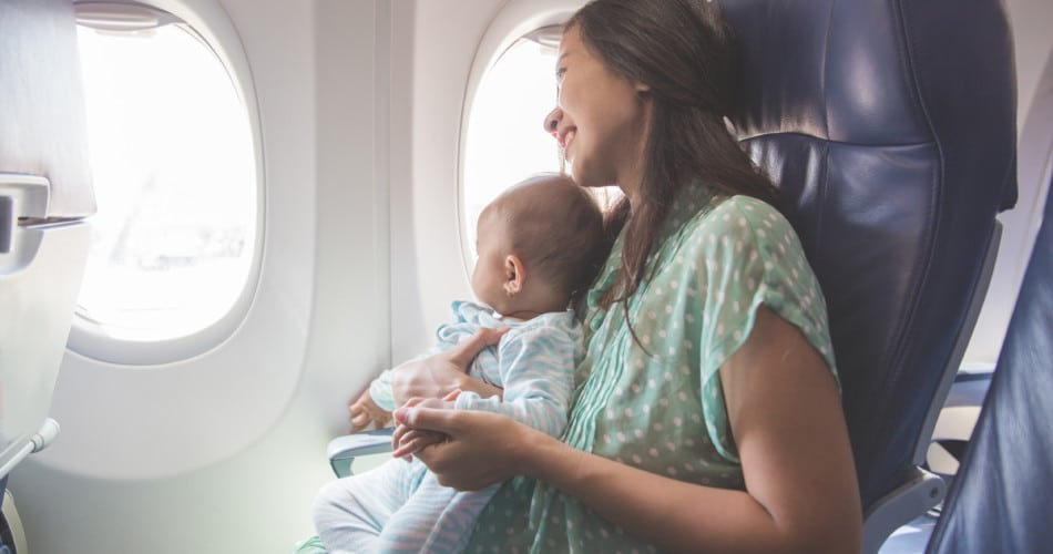 Mutter und Baby fliegen zusammen im Flugzeug.