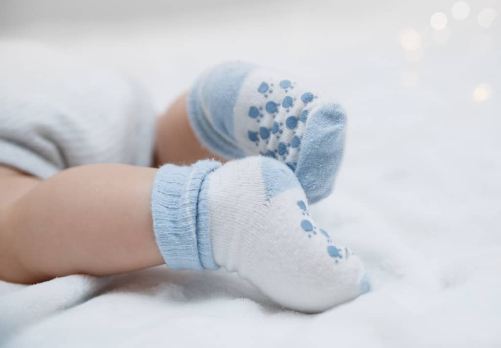 Ein Baby trägt Socken in der richtigen Sockengröße.