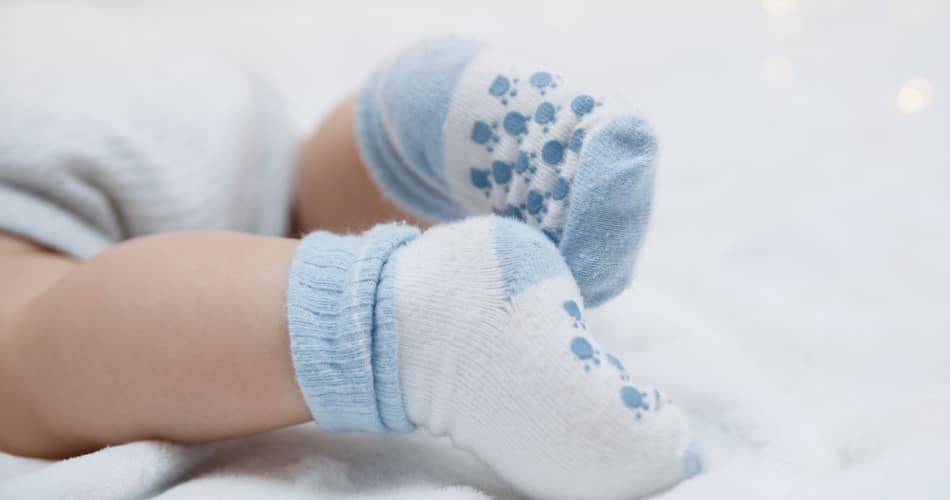 Ein Baby trägt Socken in der richtigen Sockengröße.