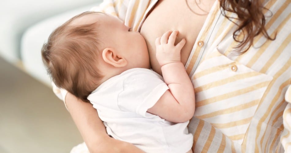 Eine Mutter stillt ihr Baby. Titelbild zum Artikel, der zeigt, wie lange Mütter ihr Baby stillen sollen.