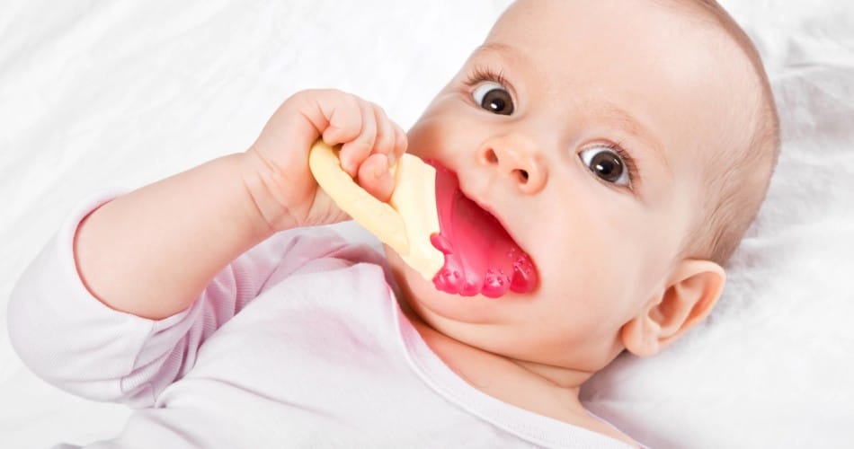 Orale Phase: Baby nimmt einen Beißring in den Mund.