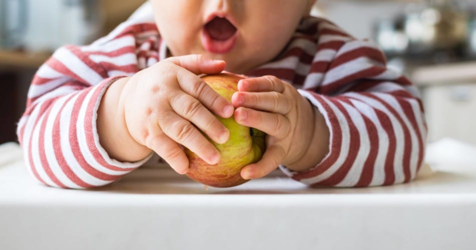 Ein Kind beißt in einen Apfel