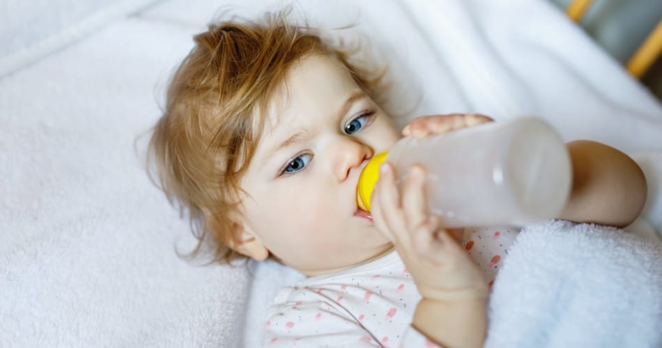 Ein Kleinkind trinkt aus einem Fläschchen. Tipps, wie man seinem Kind die nächtliche Milchflasche abgewöhnen kann.