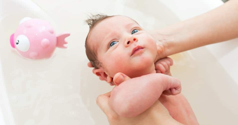 Ein Neugeborenes badet zum ersten Mal.