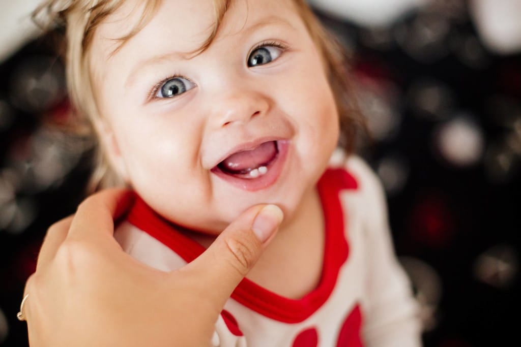 Baby zahnt: Die ersten unteren Schneidezähne eines Babys werden gezeigt.