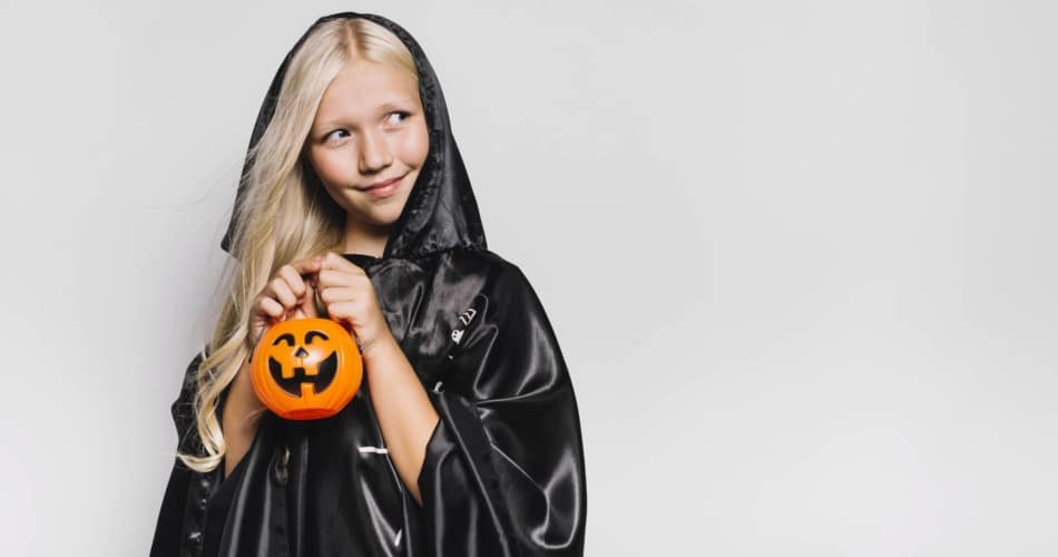 Halloweenfilme für Kinder: Ein lächelndes Mädchen mit einer Kürbislaterne in der Hand.