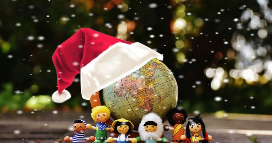 Globus mit Weihnachtsmütze und verschiedenen Spielfiguren davor