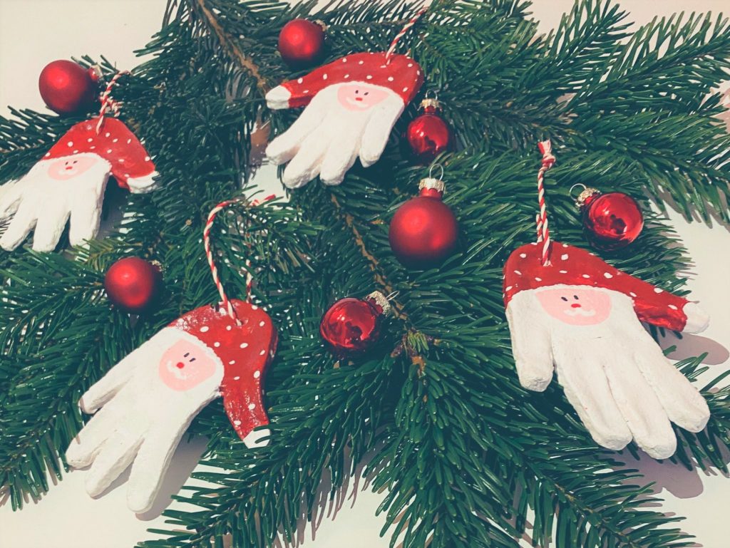 Weihnachtsmänner als Weihnachtsbaumschmuck aus Handabdrücken von Kindern basteln.
