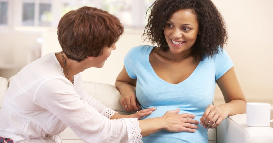 Eine Hebamme untersucht eine schwangere Frau.