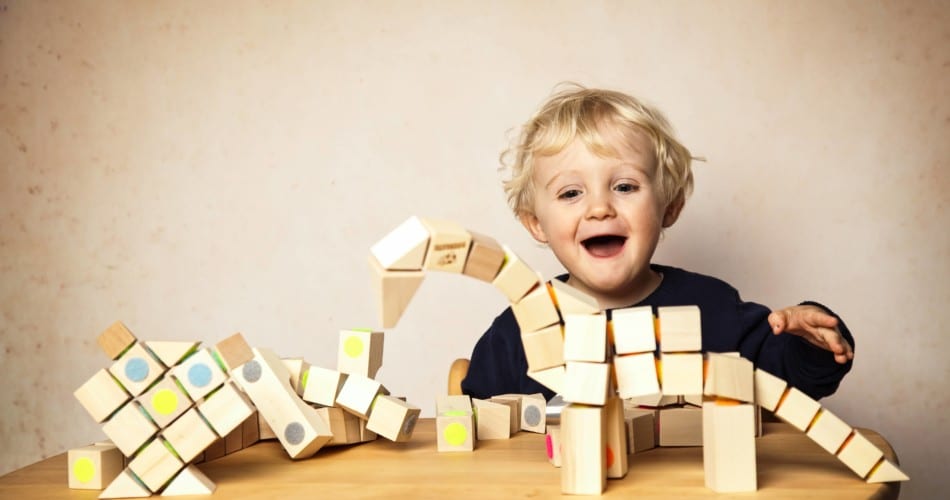 Ein Kind spielt mit Holzbausteinen mit Magneten.