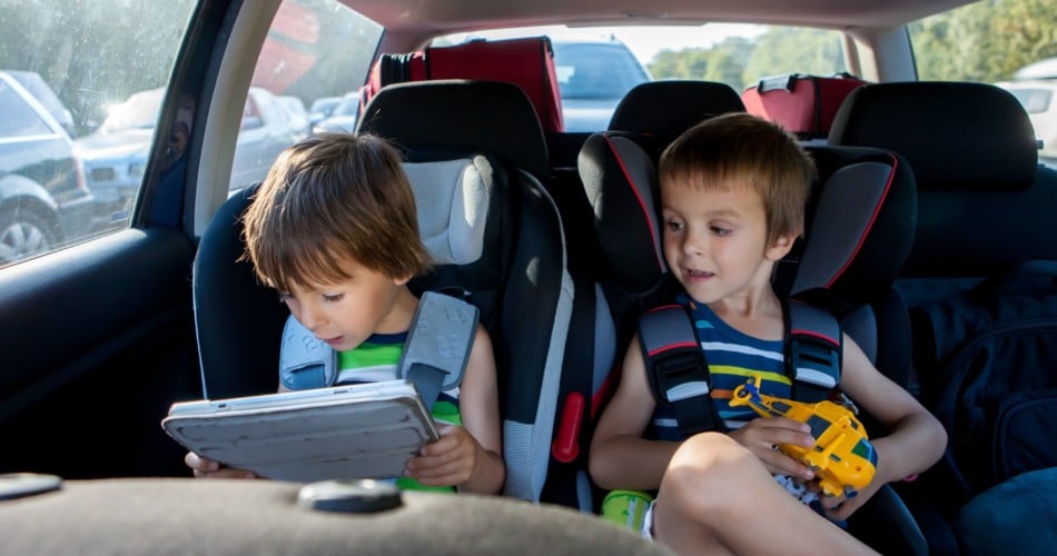 Zwei Kinder spielen im Auto.