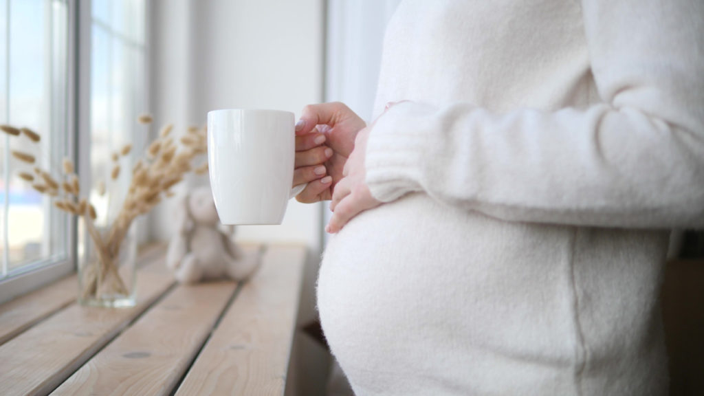 Schwangere Frau trinkt eine Tasse Tee.
