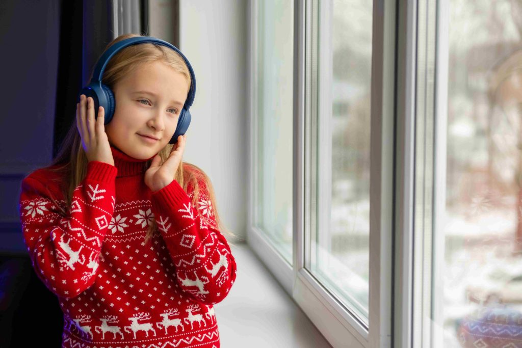 Ein Mädchen hört ein Hörbuch in der Weihnachtszeit.
