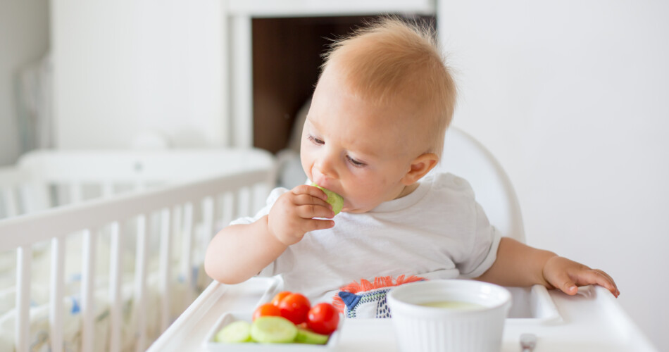 Kind bei Familienmahlzeit am essen.