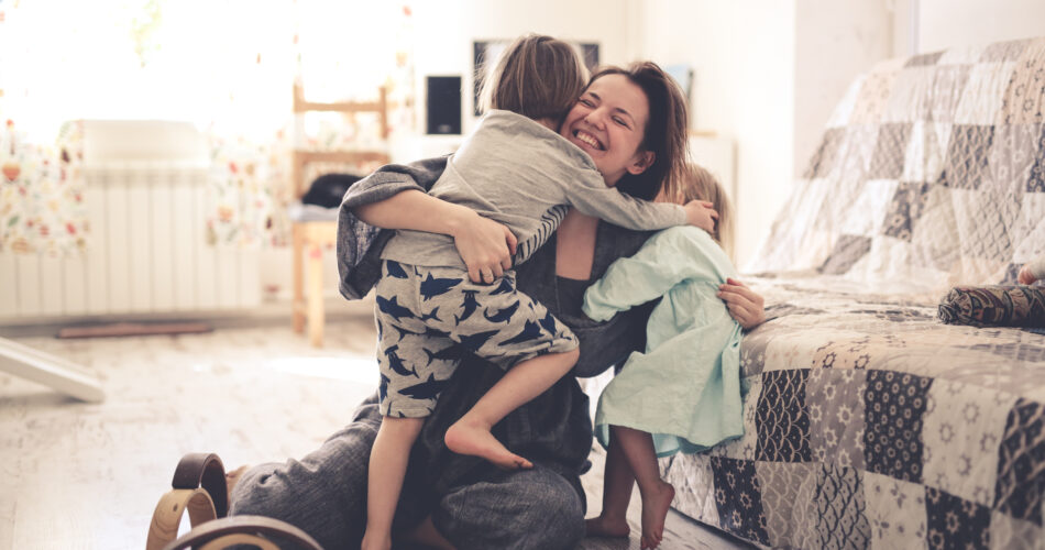 glückliche Mutter umarmt ihre Kinder