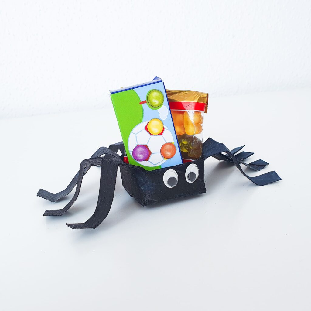 Spinne aus Klopapierrolle mit Süßigkeiten befüllt