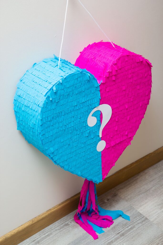 Eine Piñata in rosa und blau, die das Geschlecht eines Babys durch Süßigkeiten enthüllt.